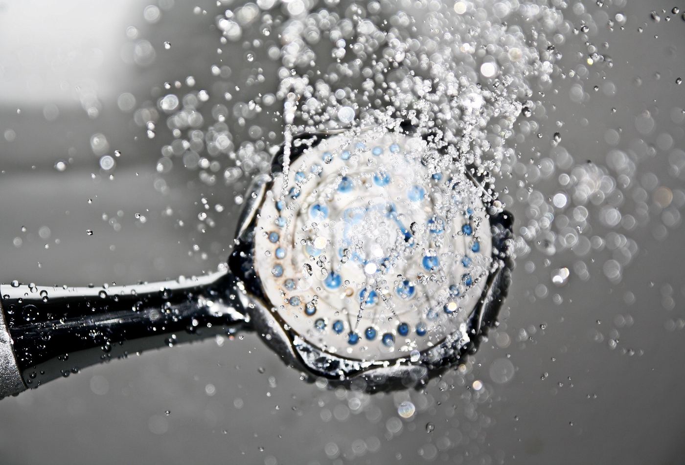 Brausekopf mit austretendem Wasserstrahl in Nahaufnahme